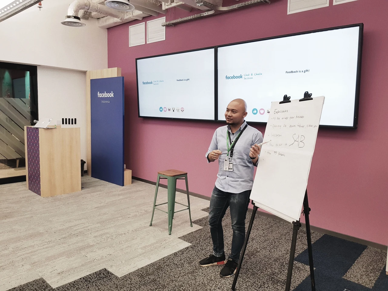 Tico Lastiko sharing ideas in a workshop, beside a presentation board